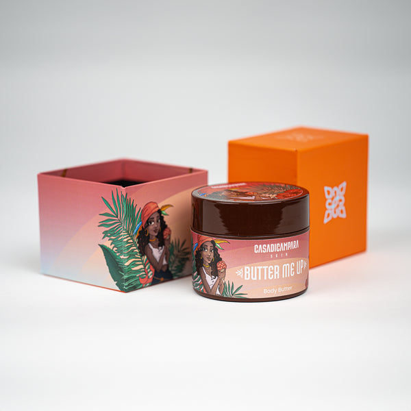 Orange Butter Me Up shea body butter with white text and girl illustration, nourishing body care essential.