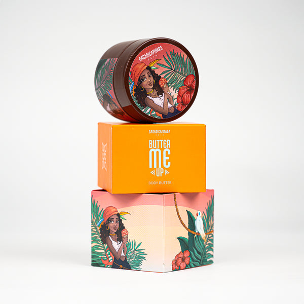Round brown shea body butter with girl illustration placed on orange packaging with white text, body care essential.
