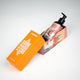 Shower gel package lying down with orange cap resting on printed bottom, featuring the bottle inside, skincare essential.