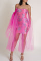 Woman wearing a Casa di Campara pink strapless dress with tulle overlay on a white background.