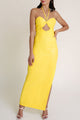 Woman wearing a Mandarin Mystique bright yellow dress from the Macao collection with a cutout, paired with white heels.