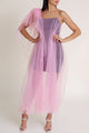 Woman wearing a black Casa Di Campara mini dress covered with pink tulle, posing in white heels.