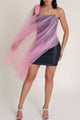 The model’s hand lifts the pink tulle overlay, revealing the sleek black base and demonstrating the airy, flowing quality of the sheer layer.