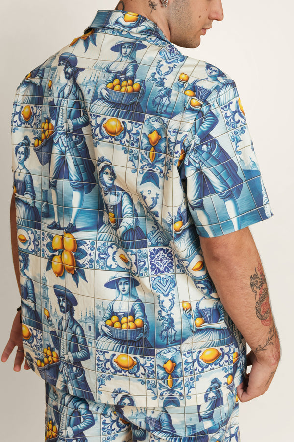 Relaxed-fit unisex zip-up shirt with intricate blue-and-white tile print and gold zipper.