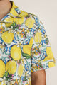 Close-up of lemon-and-leaf printed summer shirt - unisex shirt in bright citrus hues, ideal for beach days or layering over swimwear.