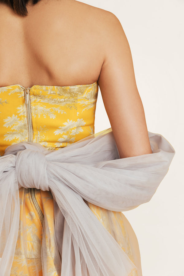 Close-up of yellow tulle dress with cotton bodice and yellow-gray print, showcasing elegant summer details from the Porto Chic collection.