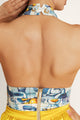 Close-up of a yellow mini dress - features a striped crop top and lemon-yellow skirt.
