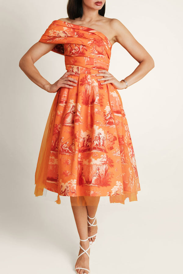 Woman wearing an orange floral one-shoulder dress on a white background.
