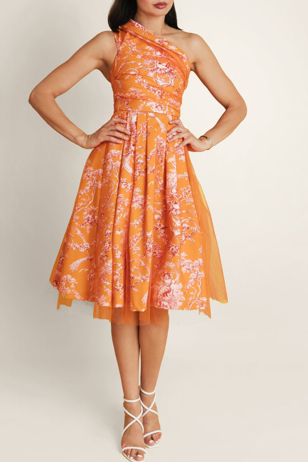 Woman in Sintra Magic orange-pink floral midi dress with off-shoulder design, made of lightweight cotton and tulle.