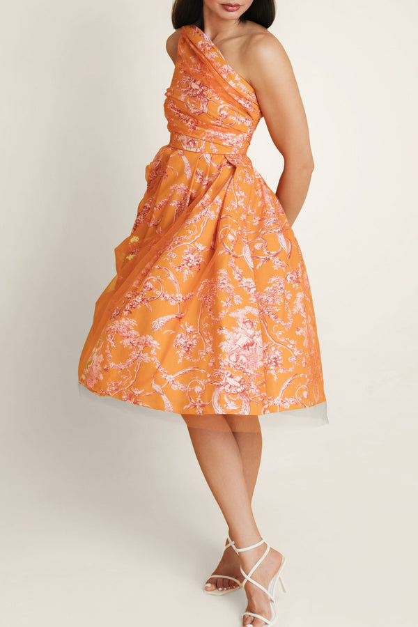 Side view of a woman in an orange-pink Sintra Magic dress with off-shoulder design, showcasing the dress in motion and its delicate floral print.