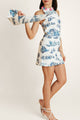 Side view of a woman in the Lagos Azure cotton dress, highlighting the flowing fabric, blue print, and pink neckline detail from Casa Di Campara.