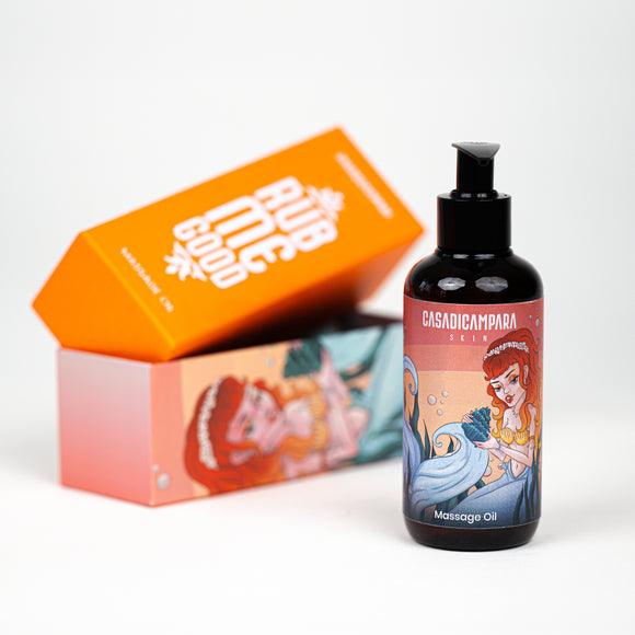 Rub Me Good massage oil bottle with mermaid illustration and pump, in front of orange packaging box.