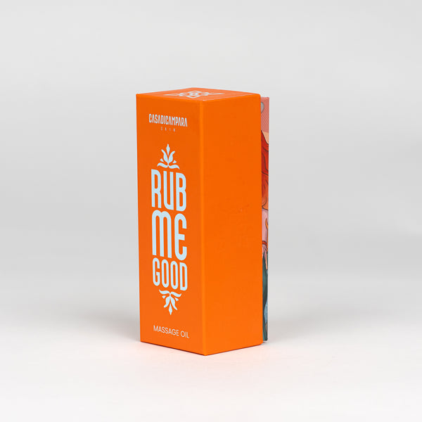 Front view of the orange packaging of "Rub Me Good" massage oil, featuring the product name in bold white letters.