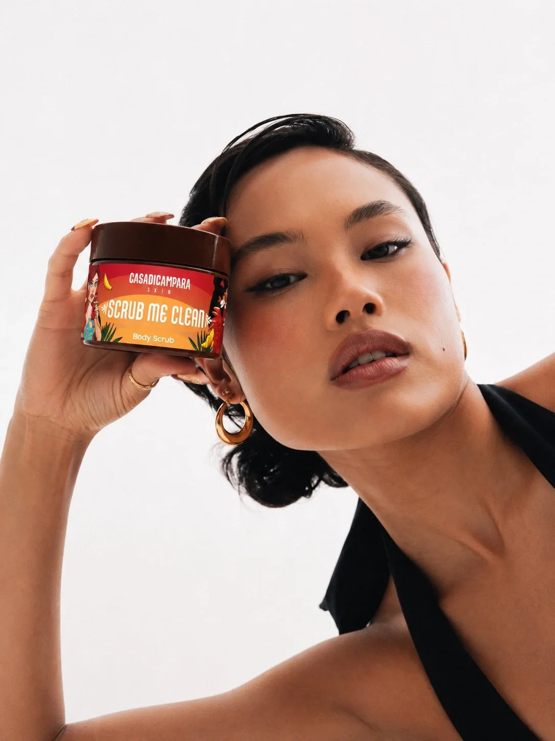 female model holding a cdc product next to her face and posing in front of a white background