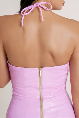 Close-up of woman in vibrant pink dress showcasing the elegant halter tie around the neck, with gold zipper and open back adding a refined finish.