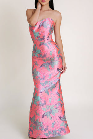 Woman in a long pink dress with floral print, showcasing vibrant colors and elegant design.