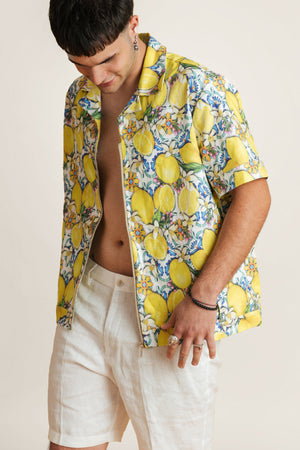 Model wearing a vibrant lemon-print summer shirt - lightweight crop-style top perfect with summer shorts for sunny escapes.