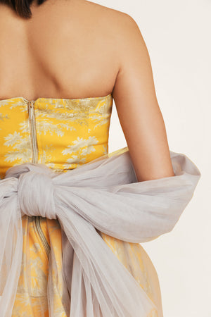 Close-up of yellow tulle dress with cotton bodice and yellow-gray print, showcasing elegant summer details from the Porto Chic collection.