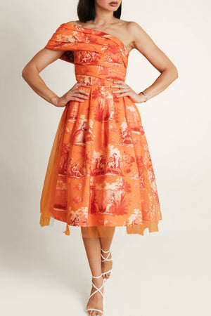Woman wearing an orange floral one-shoulder dress on a white background.